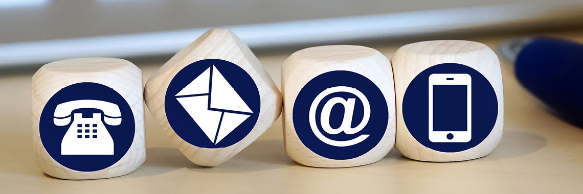 Vier Holzwürfel mit den Symbolen für: Telefonie, Email, @-Zeichen, Handy