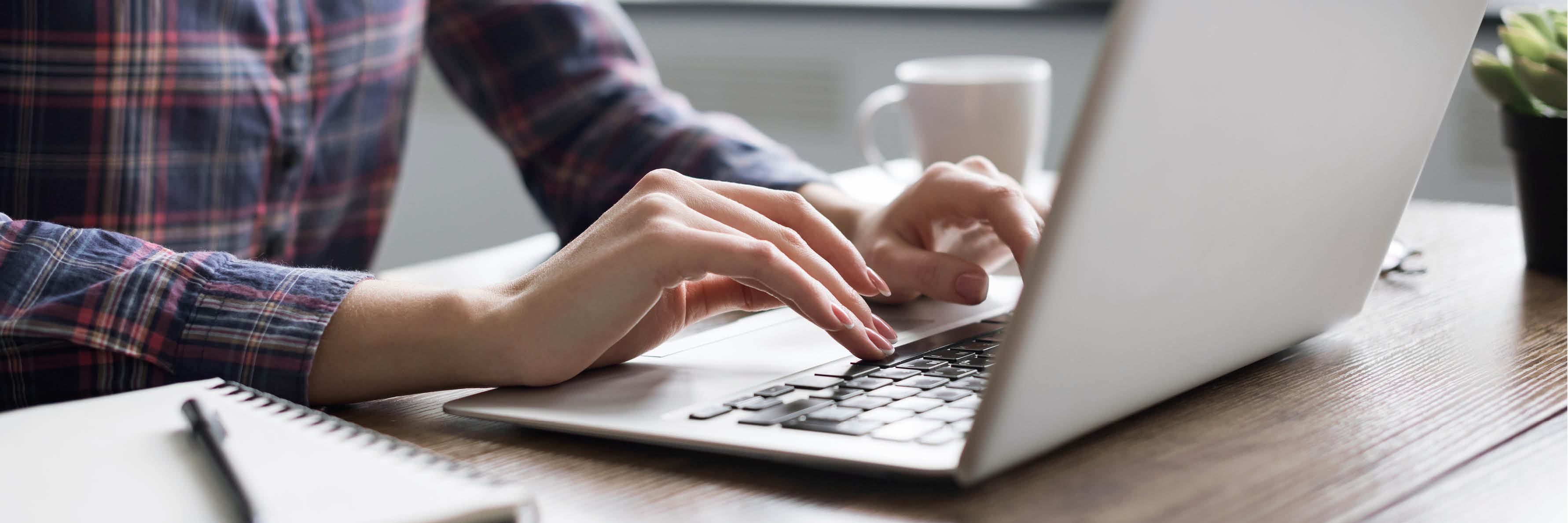 Person sitzt tippend vor Laptop