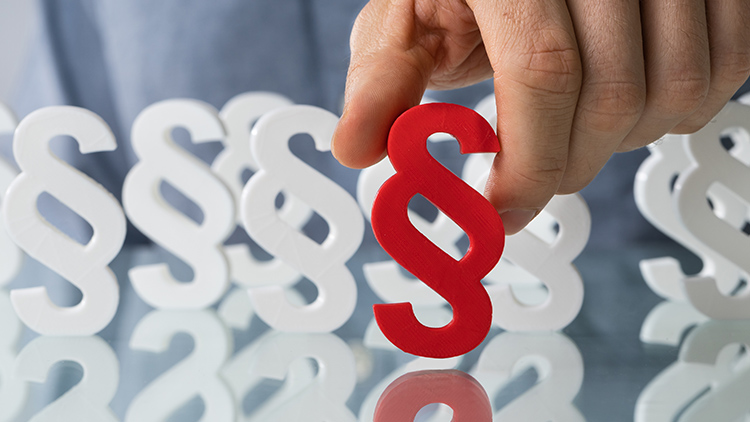 Hand stellt Paragraphensymbol auf