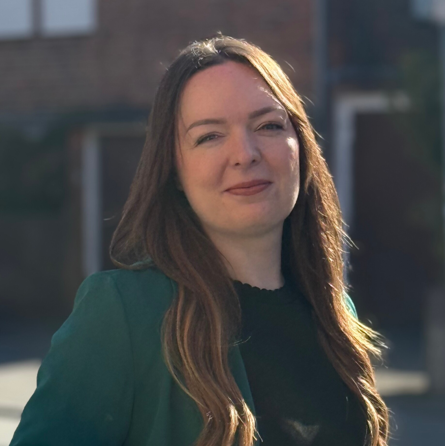 KI generiert: Ein Porträt einer lächelnden Frau im Freien mit unscharfem Hintergrund.