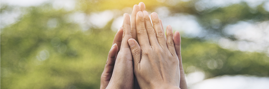 Vier Hände klatschen zusammen in der Luft