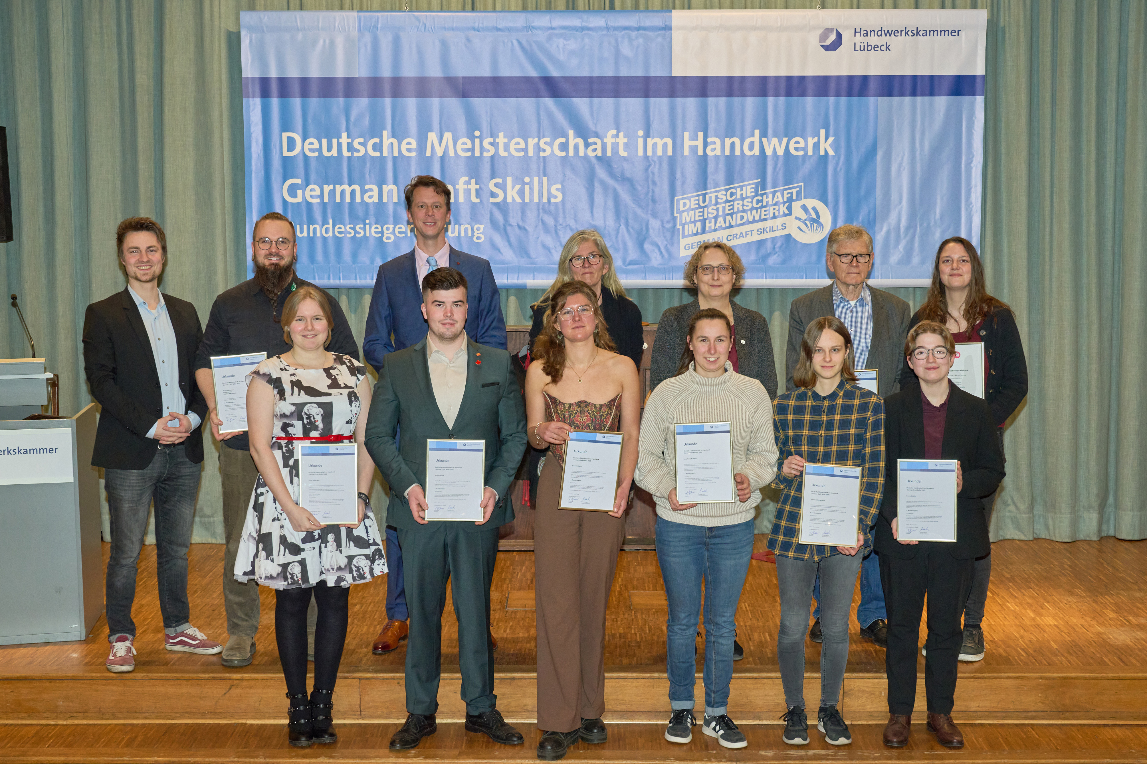 KI generiert: Eine Gruppe von Menschen posiert mit Zertifikaten vor einem Banner für die Deutsche Meisterschaft im Handwerk.